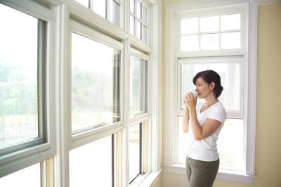 жена гледа през прозорци от PVC дограма